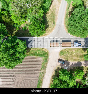 Foto aerea di un attraversamento in Germania vicino a celle al di sopra del quale un trattore con due rimorchi caricati rigidi, realizzati con drone Foto Stock