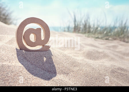 E-mail @ simbolo nella sabbia in spiaggia Foto Stock