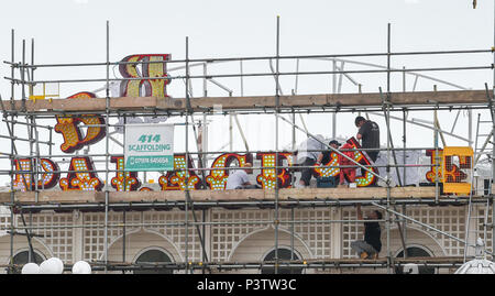 Brighton Regno Unito 19 Giugno 2018 - operai regolando la lettera P come la nuova insegna al neon per Brighton Palace Pier è eretto . Il molo è stato costruito nel 1890 e chiamato Brighton Palazzo Marino e il molo ma divenne noto localmente come il Palace Pier fino al 2000 quando è stato cambiato il nome di Brighton Pier. Luke Johnson presidente esecutivo del Molo di Brighton gruppo adesso ha annunciato che sarà noto come il Brighton Palace Pier Credit: Simon Dack/Alamy Live News Foto Stock