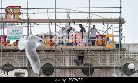 Brighton Regno Unito 19 Giugno 2018 - operai regolando la lettera P come la nuova insegna al neon per Brighton Palace Pier è eretto . Il molo è stato costruito nel 1890 e chiamato Brighton Palazzo Marino e il molo ma divenne noto localmente come il Palace Pier fino al 2000 quando è stato cambiato il nome di Brighton Pier. Luke Johnson presidente esecutivo del Molo di Brighton gruppo adesso ha annunciato che sarà noto come il Brighton Palace Pier Credit: Simon Dack/Alamy Live News Foto Stock