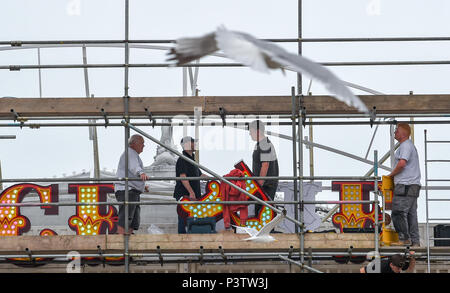 Brighton Regno Unito 19 Giugno 2018 - operai regolando la lettera P come la nuova insegna al neon per Brighton Palace Pier è eretto . Il molo è stato costruito nel 1890 e chiamato Brighton Palazzo Marino e il molo ma divenne noto localmente come il Palace Pier fino al 2000 quando è stato cambiato il nome di Brighton Pier. Luke Johnson presidente esecutivo del Molo di Brighton gruppo adesso ha annunciato che sarà noto come il Brighton Palace Pier Credit: Simon Dack/Alamy Live News Foto Stock