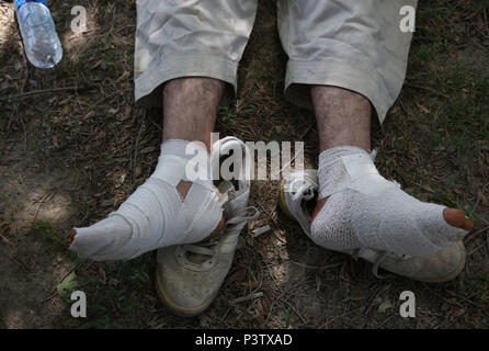 A Kabul, Afghanistan. Il 18 giugno, 2018. Una pace afghano marcher prende un periodo di riposo dopo aver camminato 700 km ed arriva a Kabul, capitale dell'Afghanistan, 18 giugno 2018. Un afghano Attivisti di pace' convoglio di più di 70 giovani, che chiede di porre fine alla guerra, sono arrivati nella capitale Kabul, dopo l'avviamento di un piede di viaggio dal sud della provincia di Helmand e trekking in diverse province, un elemento detto lunedì. Credito: Rahmat Alizadah/Xinhua/Alamy Live News Foto Stock