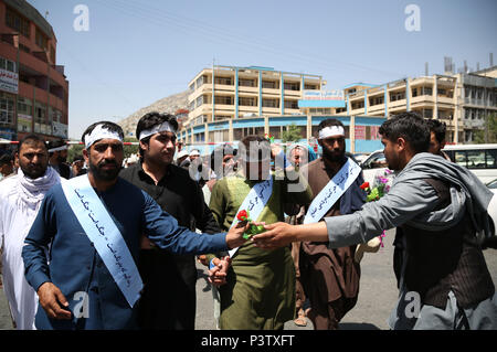 A Kabul, Afghanistan. Il 18 giugno, 2018. Afghani hanno marciato dalla pace di arrivare a Kabul, capitale dell'Afghanistan, dopo aver camminato 700km, 18 giugno 2018. Un afghano Attivisti di pace' convoglio di più di 70 giovani, che chiede di porre fine alla guerra, sono arrivati nella capitale Kabul, dopo l'avviamento di un piede di viaggio dal sud della provincia di Helmand e trekking in diverse province, un elemento detto lunedì. Credito: Rahmat Alizadah/Xinhua/Alamy Live News Foto Stock