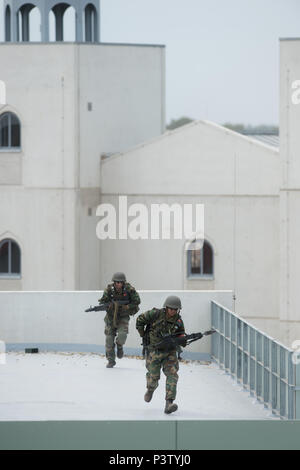 Letzlingen, Germania. 19 giugno 2018. Due di formazione a difendere i partecipanti abbandonano la loro posizione su un tetto di un edificio in un addestramento militare townSchnoeggersburg. Alla formazione militare comune alla Altmark zona di addestramento militare intorno a 2000 soldati provenienti da Germania e altri partner della NATO membri addestrato i loro Combat Readiness. È stata la prima grande esercizio del tedesco federale della difesa presso la nuova formazione militare città Schnoeggersburg. Credito: Klaus-Dietmar Gabbert/dpa-Zentralbild/ZB/dpa/Alamy Live News Foto Stock