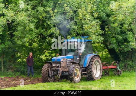 Ballydehob, Irlanda. 19 giugno 2018. Ballydehob basato dairy farmer Ben Deane orologi come appaltatore ara il suo campo di erba per la reimpostazione. Credito: Andy Gibson/Alamy Live News. Foto Stock