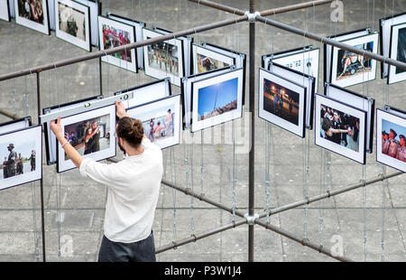 Hannover, Germania. 19 giugno 2018. Studente di Marvin organizza le foto di una copertura in corrispondenza della zona esterna della Lumix festival per giovani fotogiornalismo. Il giornalismo fotografico e documentario photorgaphy corsi di studio dell'Hochschule Hannover (Università di Scienze Applicate e Arti) girare l'ex-Expo motivi in una grande mostra fotografica dal 20 al 24 giugno 2018. I visitatori possono guardare avanti a 60 coperture con più di 1400 immagini. Credito: Hauke-Christian Dittrich/dpa/Alamy Live News Foto Stock