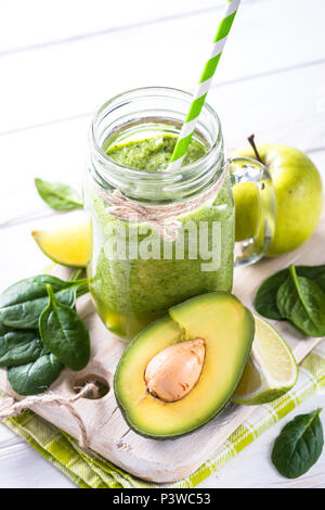 Frullato di verde e gli ingredienti su bianco tavolo in legno. Lime, Apple, spinaci, kiwi, avocado Foto Stock