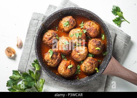 Le polpette di carne in salsa di pomodoro in una padella. Vista dall'alto su sfondo bianco. Foto Stock