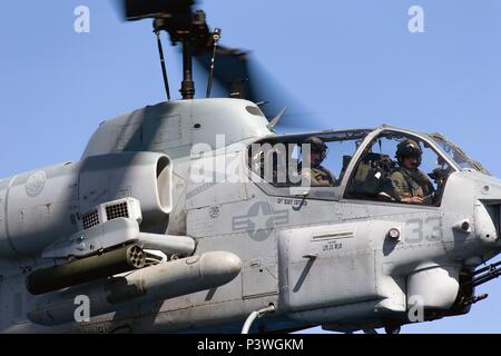 Un corpo della marina degli Stati Uniti AH-1W Super elicottero Cobra rende un approccio alla terra a bordo di HMAS Canberra durante RIMPAC 2016. Bordo del Pacifico (RIMPAC) è un U.S. Flotta del pacifico-hosted multinazionale biennale esercizio marittimo progettato per promuovere e sostenere la cooperazione internazionale sulla sicurezza degli oceani di tutto il mondo. (Australian Defence Force foto di poi Yuri Ramsey) Foto Stock