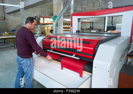 Macchine taglio laser operatore di produzione per trasferimento tessile industria moda factory Foto Stock