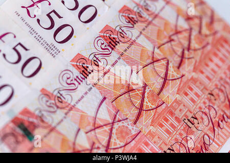 Sullo sfondo di una fila ordinata di cinquanta UK pound banconote sterling Foto Stock