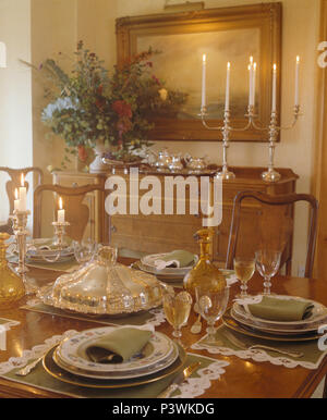 Antica vetreria e terrina di argento sul tavolo per il pranzo nel paese sala da pranzo con candelieri in argento sulla sponda Foto Stock