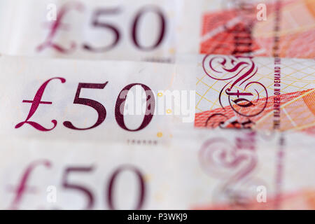 Sullo sfondo di una fila ordinata di cinquanta UK pound banconote sterling Foto Stock