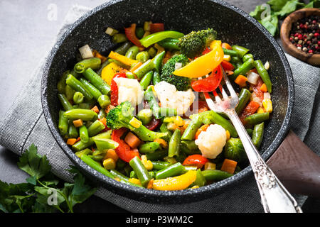 Rosolare le verdure nel wok. Sano cibo vegan. Basso contenuto calorico piatto Foto Stock