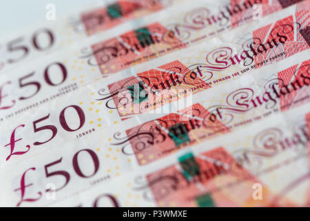 Sullo sfondo di una fila ordinata di cinquanta UK pound banconote sterling Foto Stock