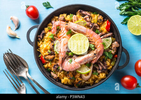 La paella di frutti di mare. Tradizionale piatto spagnolo, cucina europea. Vista dall'alto sul tavolo blu. Foto Stock