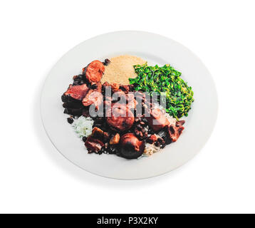 Feijoada, tipica cucina brasiliana. Feijoada su un piatto bianco con riso bianco, nero fagioli, salsicce, carne di maiale, pancetta, brasati couve e farina di manioca. Foto Stock
