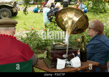 Coppia che ascolta il vecchio giocatore di Gramophone al Valley Gardens 1940's Day, Harrogate, North Yorkshire, Inghilterra, UK. Foto Stock