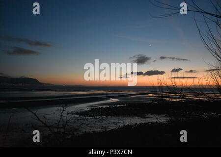 West shore, Llandudno, Galles del Nord, Regno Unito - tramonto invernale, vista di Anglesey sullo sfondo Foto Stock