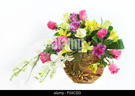 Composizione floreale in vaso naturale isolato su uno sfondo bianco. Composizione con giallo, rosa, viola e fiori bianchi e fatti a mano, vaso naturale Foto Stock