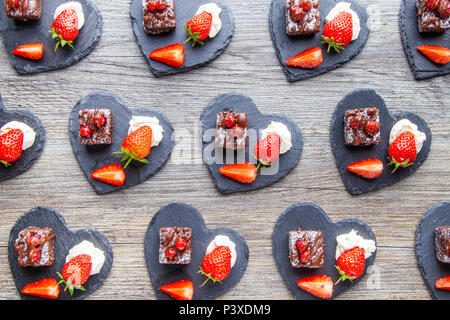 La fragola e Brownie antipasti sul cuore piastre sagomate Foto Stock