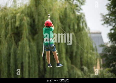 CLUJ, Romania - 17 giugno 2018: bambino su una discesa zipline nel parco durante il Festival dello Sport Foto Stock