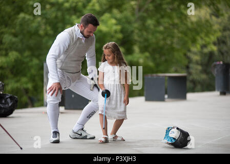 CLUJ, Romania - 17 giugno 2018: Fencer learning ragazza giovane scherma e mettere in pratica con la spada durante il Festival dello Sport Foto Stock