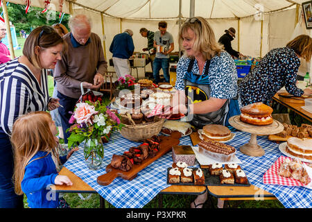 Persone che acquistano dolci presso un villaggio tradizionale sagra, Alta Hurstwood, Sussex, Regno Unito Foto Stock