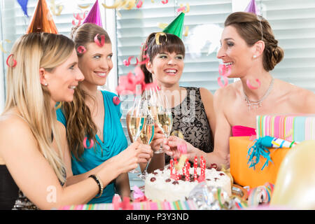 Quattro belle e vivaci donne tostare con champagne Foto Stock