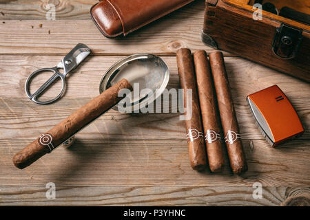 Sigari cubani e accessori per fumatori su sfondo di legno, vista dall'alto Foto Stock