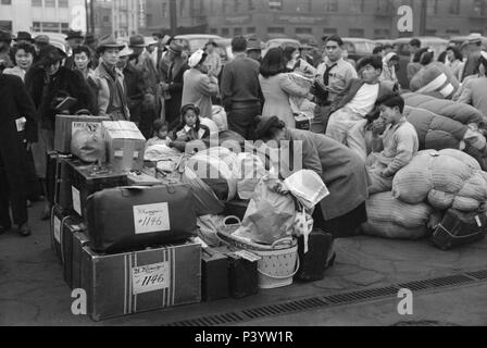 Japanese-Americans con bagaglio in attesa del treno per Owens Valley durante l'evacuazione di Japanese-Americans dal West Coast zone sotto U.S. Esercito guerra ordine di emergenza, Los Angeles, California, USA, Russell Lee, Ufficio di informazione di guerra, Aprile 1942 Foto Stock