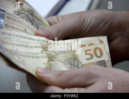 Dinheiro do Brasil, notas de Real, moeda brasileira. Na foto, mãos segurando notas de 50 reais. Foto Stock