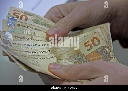 Dinheiro do Brasil, notas de Real, moeda brasileira. Na foto, mãos manipulando notas de 50 reais. Foto Stock