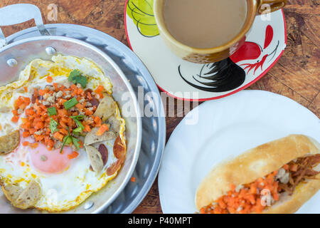 Nord-est colazione tailandese con caffè, padella calda uovo fritto farcite con carne macinata di maiale e salsiccia, comuni anche per il vietnamita e il Laos persone Foto Stock