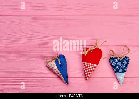 Il giorno di San Valentino con uno sfondo con cuori fatti a mano. Set di tessuto colorato cuori per San Valentino vacanza e copia dello spazio, vista dall'alto. Foto Stock