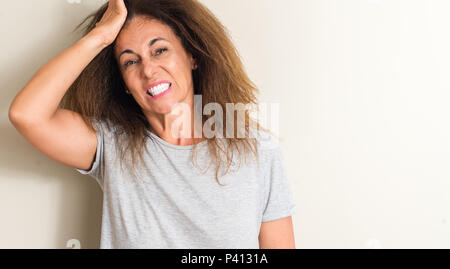 Capelli arricciati donna brasiliana ha sottolineato con la mano sulla testa, sconvolto con vergogna e la sorpresa di fronte, arrabbiati e frustrati. Paura e sconvolti per l'errore. Foto Stock