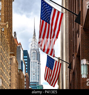 New York, Stati Uniti d'America, 19 giugno 2018. Il Chrysler building è visto dietro di noi le bandiere pendenti da Lexington Avenue edifici di New York City's Upper East Side. Foto Stock