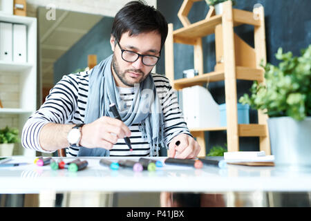 Uomo Barbuto lavorare sulla nuova pittura Foto Stock