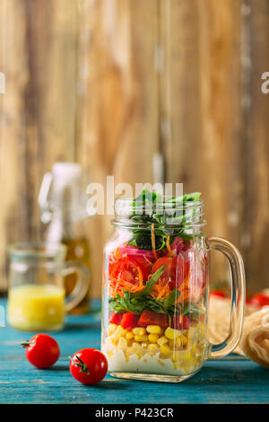 In casa sani Mason Jar insalata con ceci, mais, carote, cetrioli, peperoni, radicchio, rucola e spinaci - cibo sano, la dieta o disintossicante, Veg Foto Stock