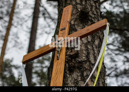 Santa Croce a una strada sterrata nel bosco. Un boscoso sentiero sabbioso conduce attraverso un bosco di pini. Stagione di estate. Foto Stock