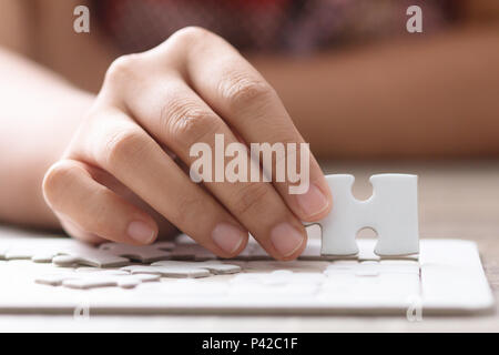 Immagine ravvicinata le mani della donna che mantiene la carta puzzle selezionare focus leggera profondità di campo Foto Stock
