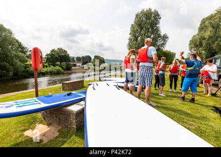 Stand Up Paddle boarding con ispirare a avventura sul fiume Wye a Monmouth. Foto Stock