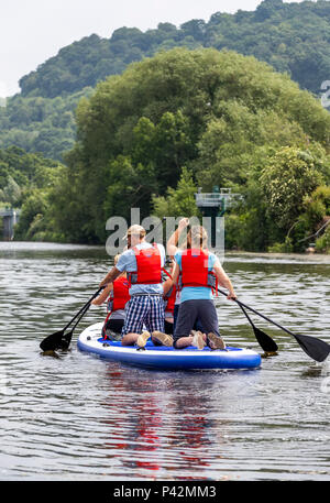 Stand Up Paddle boarding con ispirare a avventura sul fiume Wye a Monmouth. Foto Stock