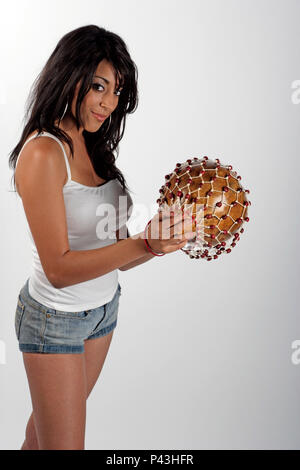 Donna Brazilain giocando un shekere. strumento a percussione Foto Stock