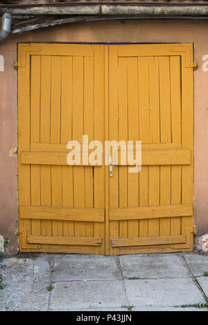 Vecchio chiuso giallo in legno porte di garage Foto Stock