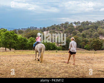 Un giovane bambino ad imparare a cavalcare in alto la Hunter Valley, NSW, Australia. Foto Stock