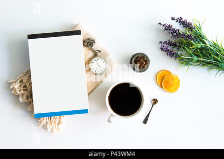 Tazza di caffè e un libro sul tavolo con secchi Arance e il vecchio orologio da tasca foglia verde. Il caffè e il libro sul tavolo bianco con i chicchi di caffè. Tempo di caffè Foto Stock