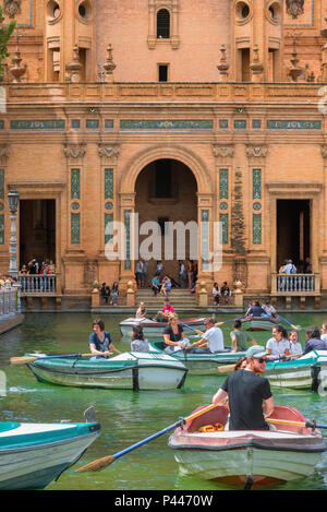 Siviglia Plaza de Espana, vista di turisti imbarcazioni a remi in barca il lago nella Plaza de Espana in un pomeriggio d'estate, Sevilla, Andalusia. Foto Stock