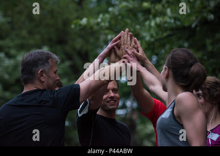 Gruppo di corridori sani dando alta cinque per ogni altro mentre celebriamo il successo dopo una sessione di formazione. Foto Stock