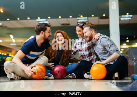 Allegro amici bowling insieme Foto Stock